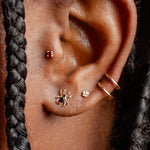 Close-up of an ear with earrings and braided hair