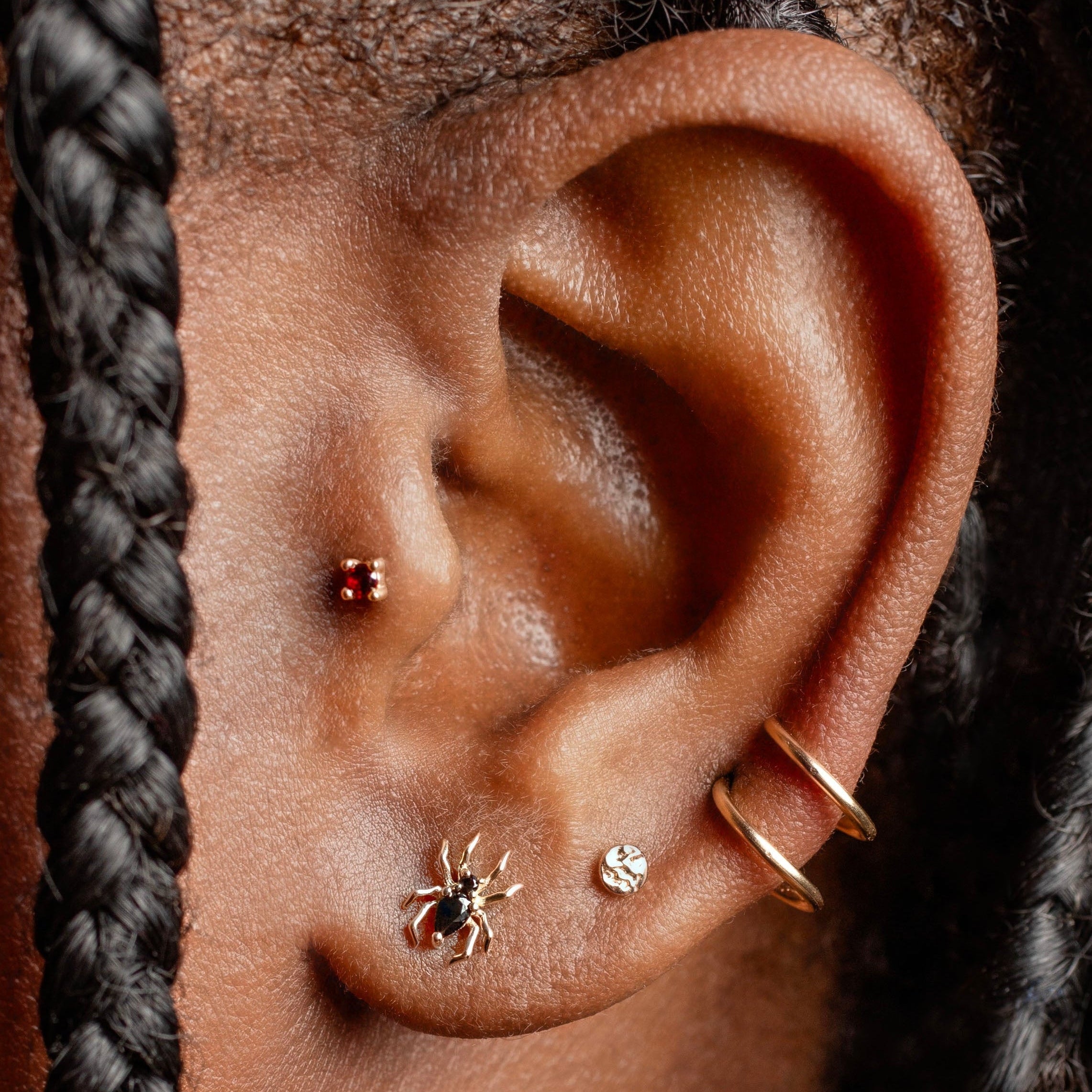 Close-up of an ear with earrings and braided hair