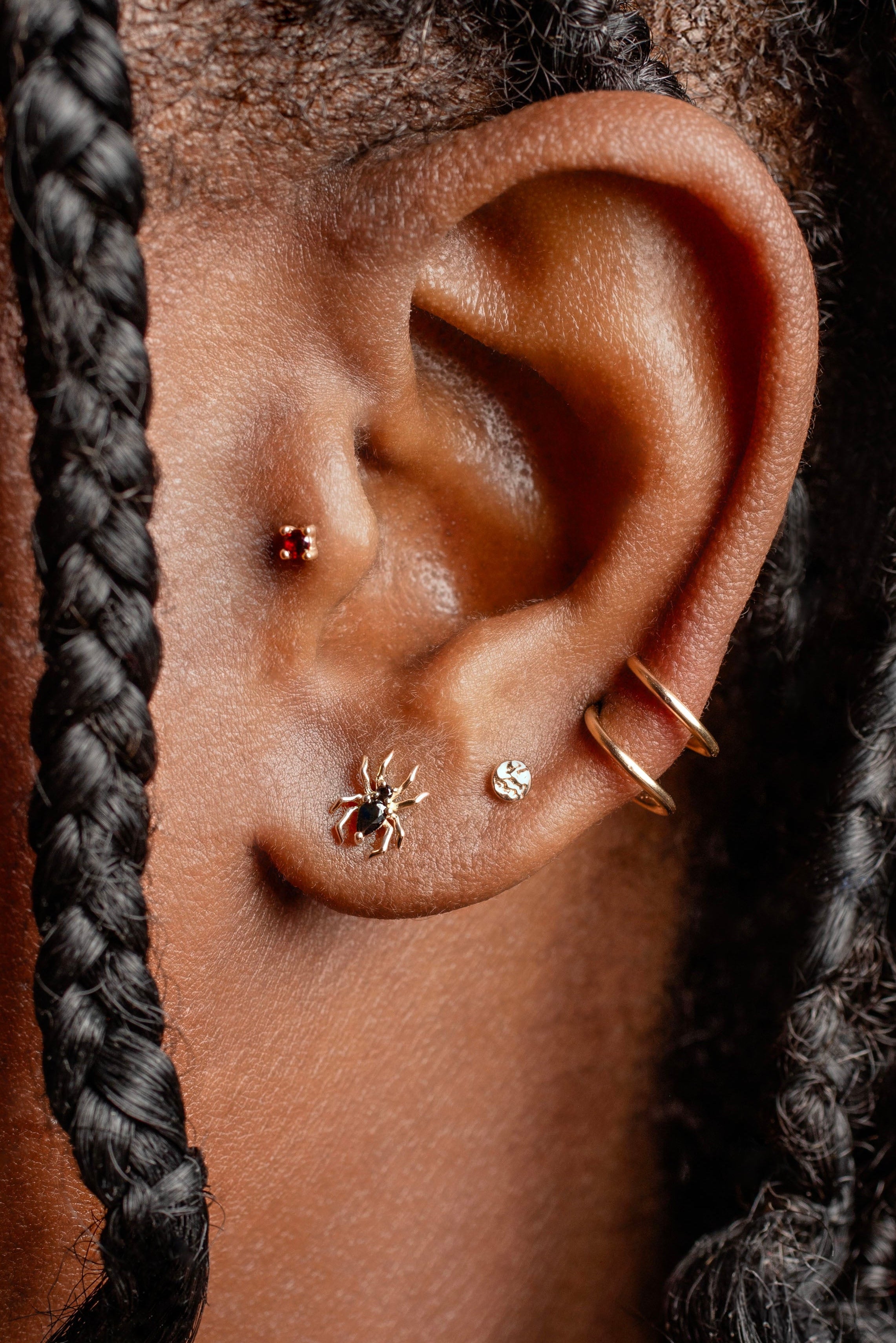 Close-up of an ear with earrings and braided hair
